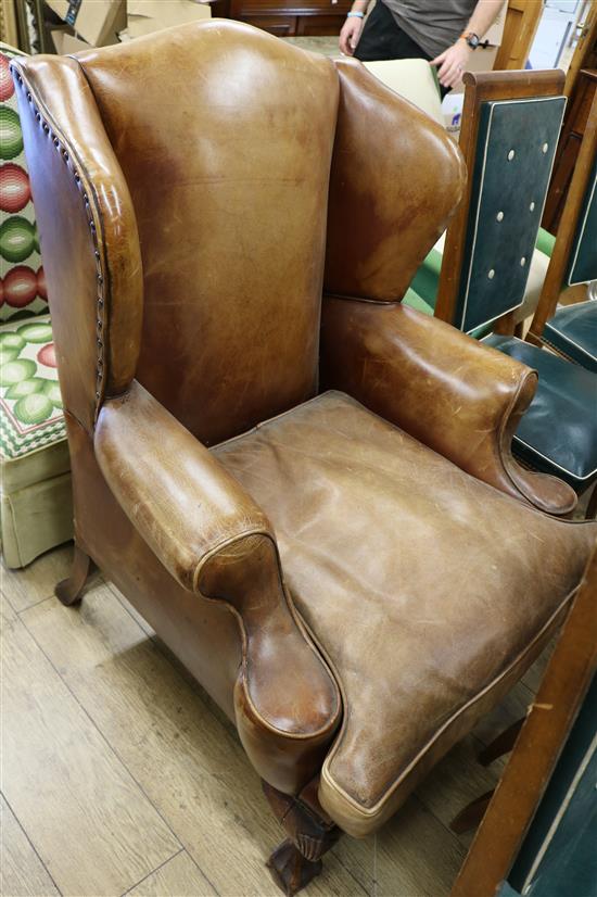 A George II-style mahogany brown leather upholstered wing armchair